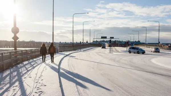 people walking on a public sidewalk covered in snow