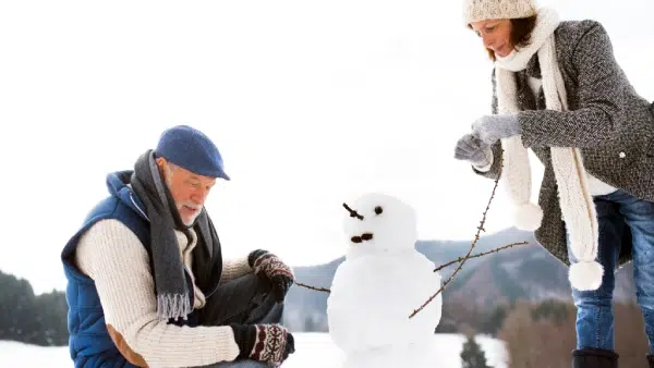 a man and woman making a snowman